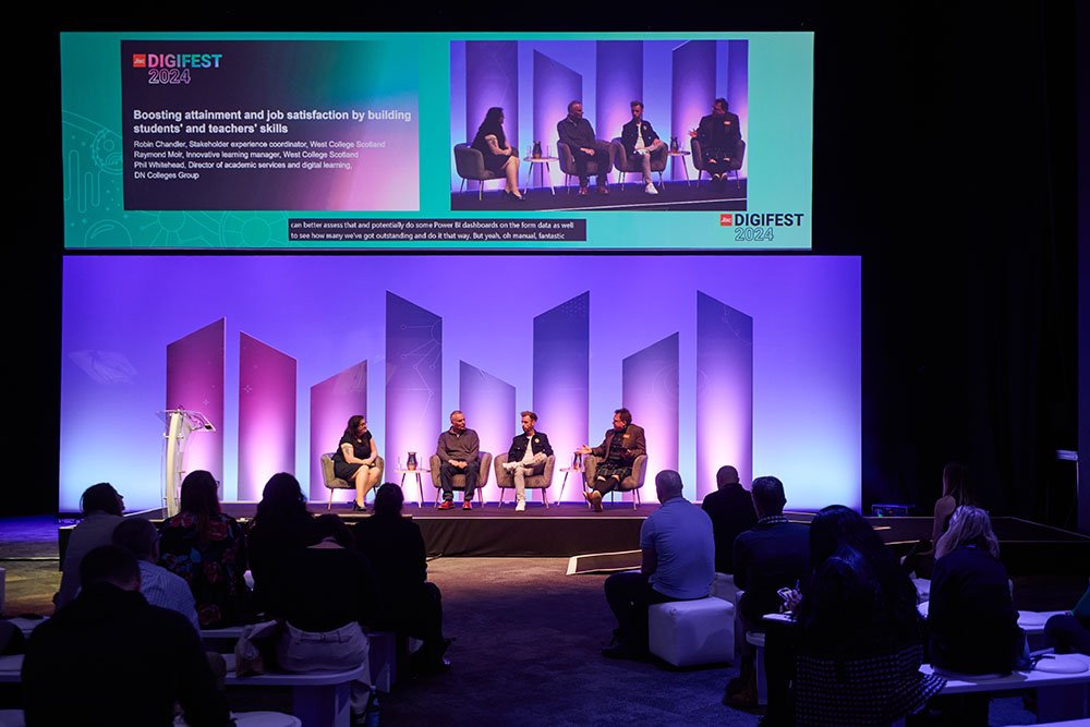 Four speakers on stage at an event.