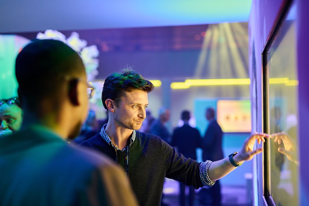 Two delegates looking at a screen.