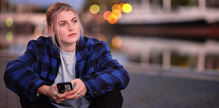 Female student holding a mobile phone.