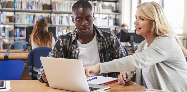 Male student and tutor studying on a laptop.