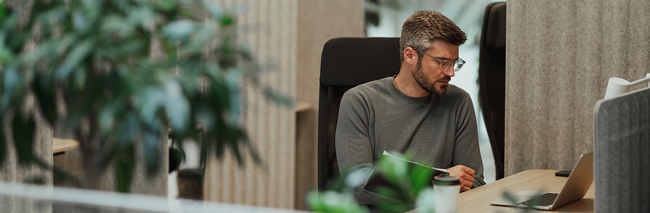 A man uses a computer at his desk.