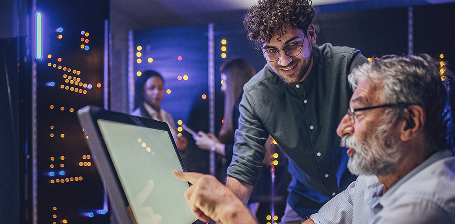Two colleagues pointing to a laptop screen.