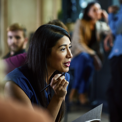 A professional woman talks with others in a relaxed environment.