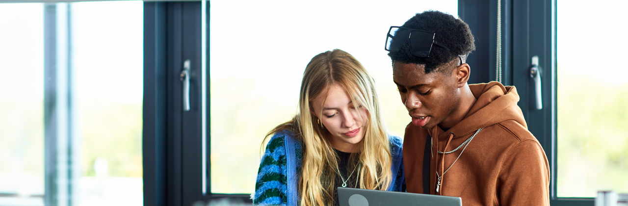 Two young students working in technical lab with computer, planning, strategy, innovation