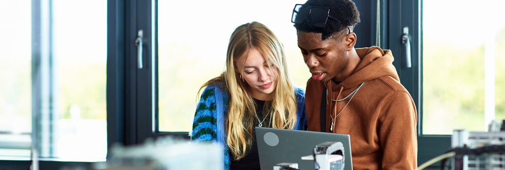 Two young students working in technical lab with computer, planning, strategy, innovation