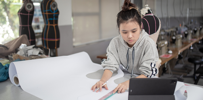 Female fashion college student doing clothing project at college workshop