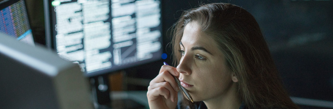 Woman working using multiple monitors