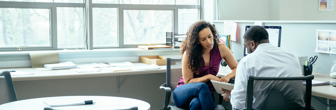 Woman and man talking in an office.