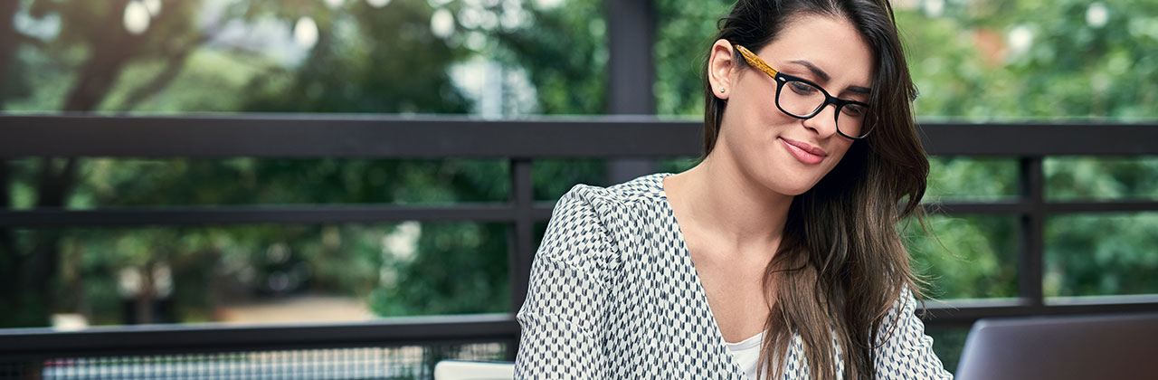 A woman works on her laptop in a park.