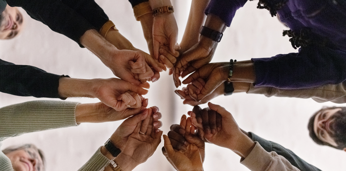 People with fist put together during support group session