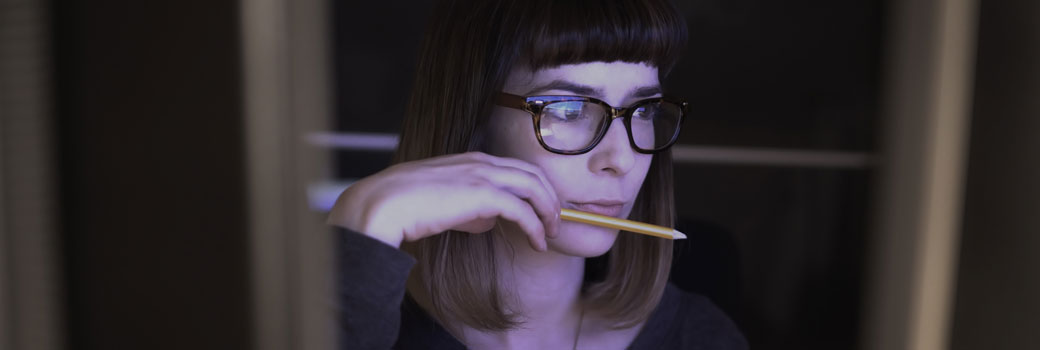 A woman looks at a computer screen.