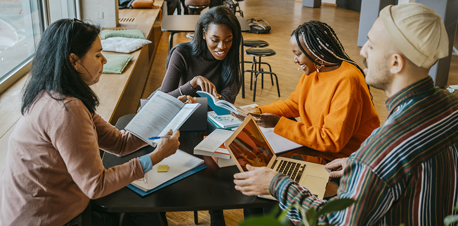 A mixed group of university students studying at a round table.
