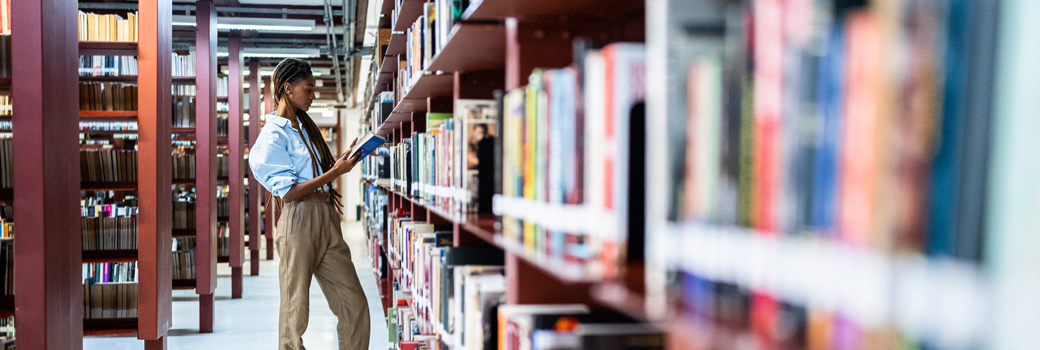 Young woman searching books in the library