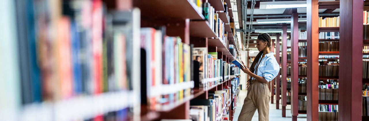 Young woman searching books in the library